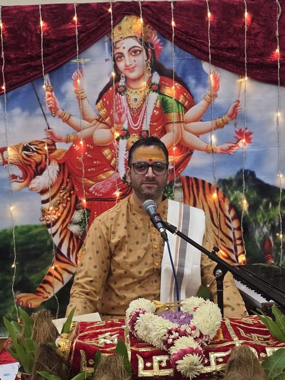Hindu priest leading prayers before the goddess Durga