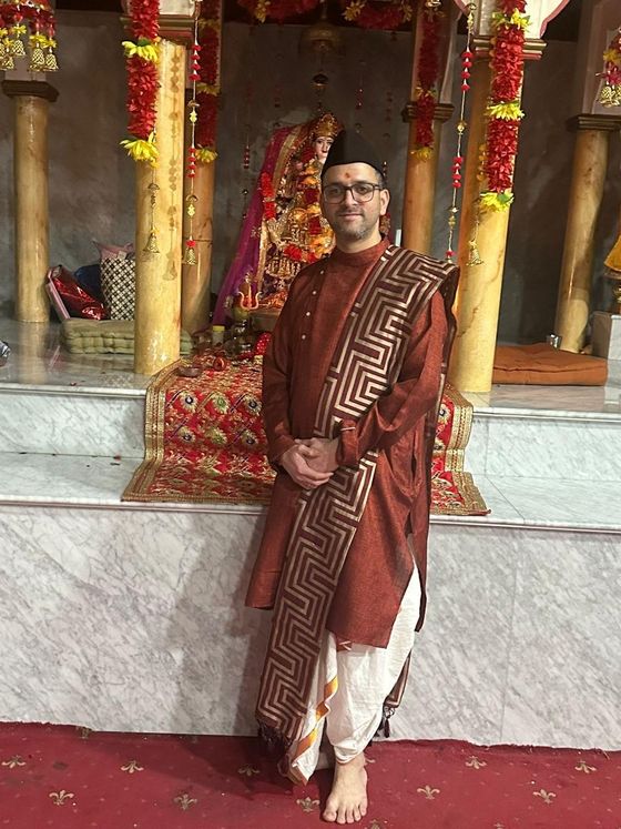 Hindu pandit standing before the temple deities